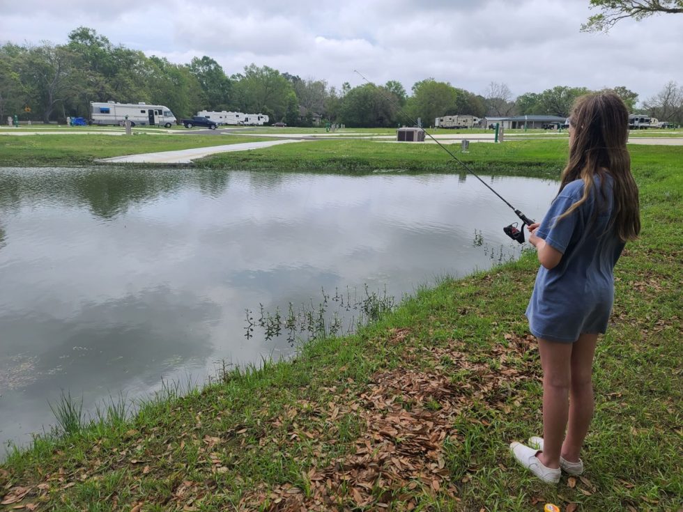 Photo of a young woman fishing at Homestead RV Community.